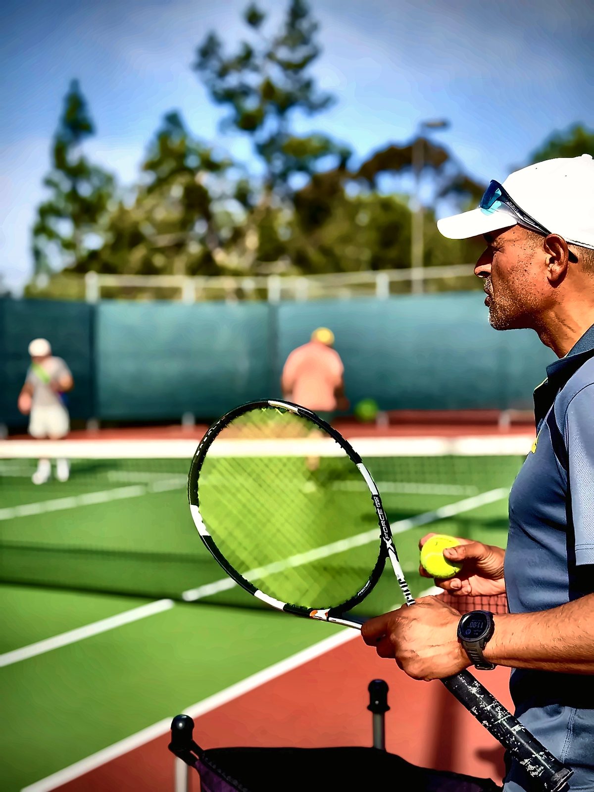 Coach Fawz holding a racket and ball before a private lesson