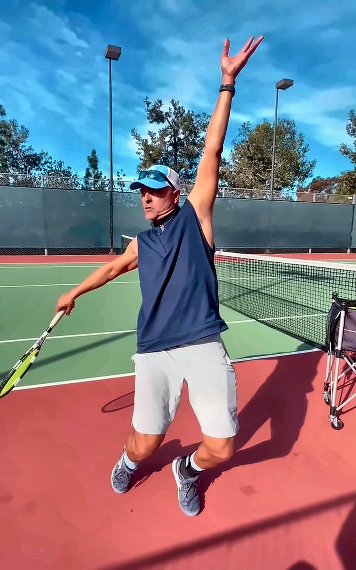 Player reaching up on the serve during a lesson
